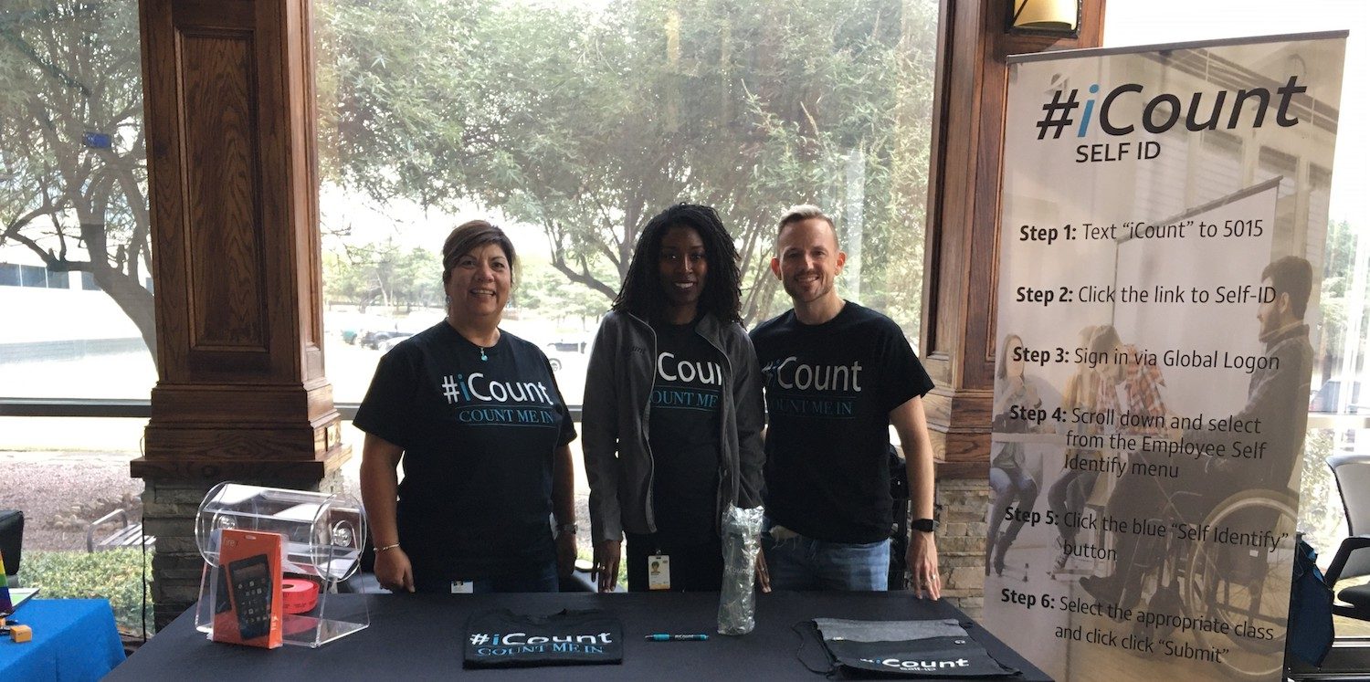 3 members of icount team standing at outdoor booth
