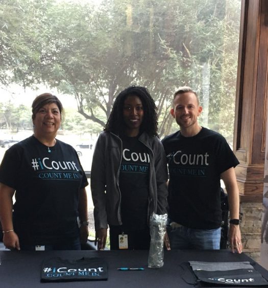 3 members of icount team standing at outdoor booth